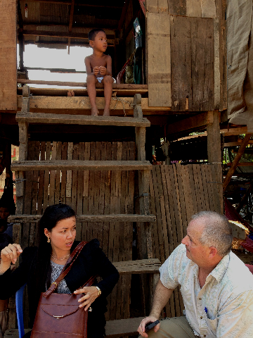 Sokhoeun with CGI President Chris Alexander visiting a poor family in Battambang.